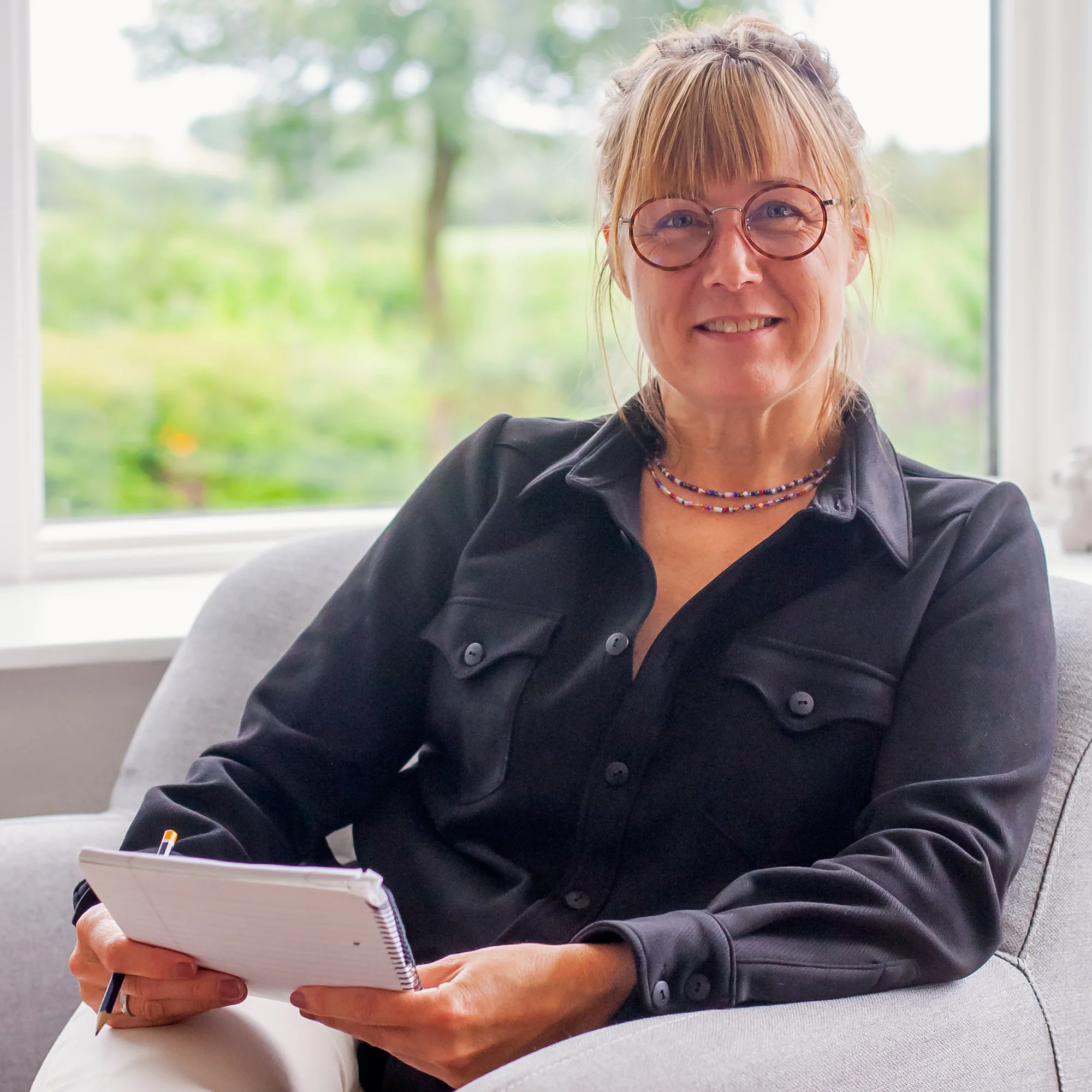 Therapist sitting in chair taking notes